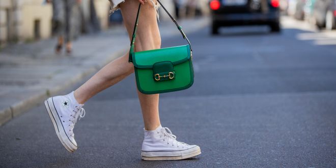Lisa Banholzer trägt weiße High-Top Converse mit einer grünen Gucci-Tasche in Berlin.
