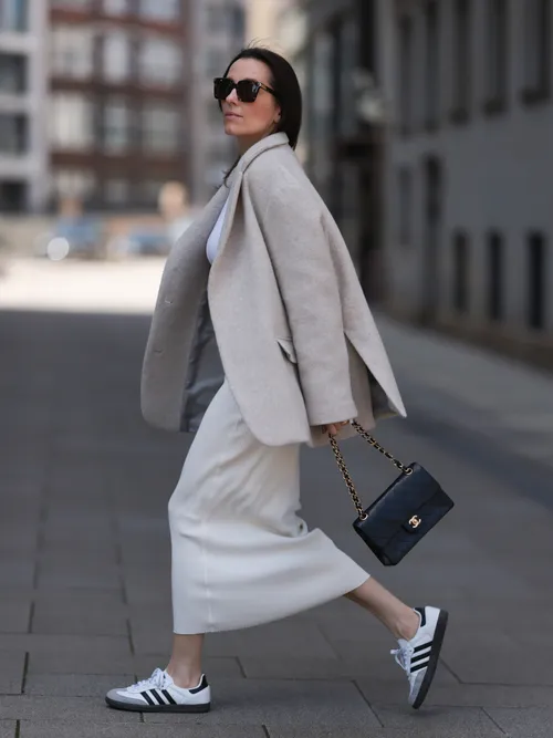 Elise Seitz trägt einen Wollblazer mit Strickrock und Adidas Sneaker in Hamburg.
