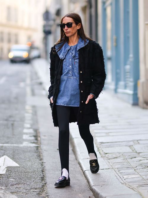 Chloe Harrouche in einer schwarzen Leggings, einer Jeansbluse und Loafers von Chanel.