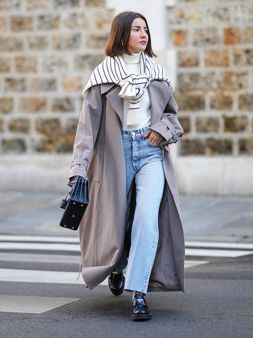 Streetstyle mit einer Jeans einem grauen Mantel und einem um die Schulter gebundenen Pullover.