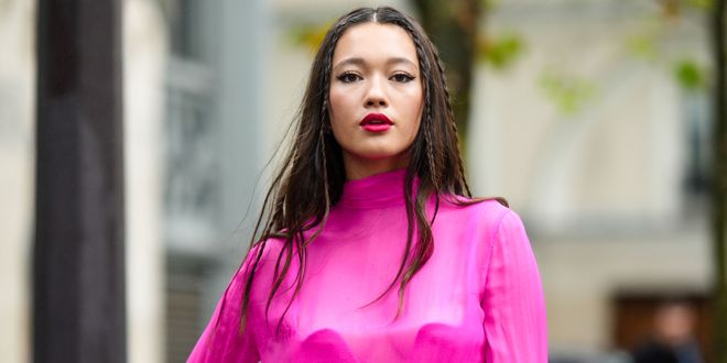 Street Style Look von der Paris Fashion Week, wo ein Gast eine pinkes Outfit mit einer Flechtfrisur trägt.