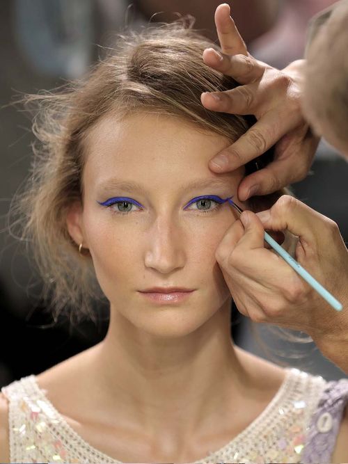 Model dass gerade einen blauen Eyeliner verpasst bekommt.