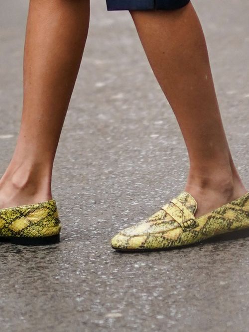 Close-up von einem Gast auf der Paris Fashion Week die gelbfarbene Loafers mit Animalprint trägt