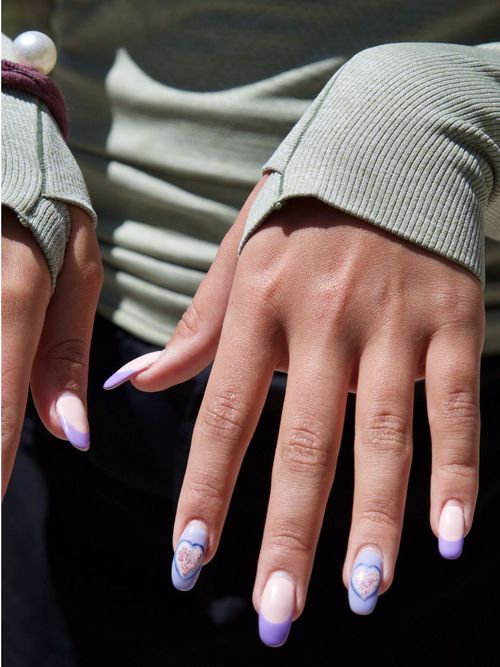 Close-up von manikürten Nägel in Violett mit kreativem und abstraktem Nageldesign.