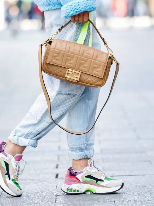 Close Up eines Stylings mit einer Jeans, Sneakers und einer Baguett Bag.