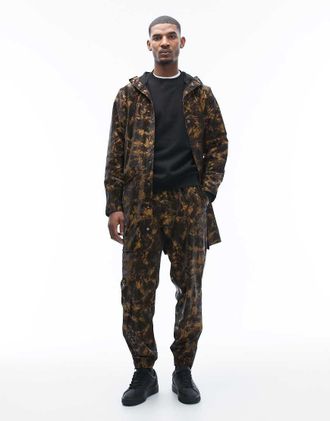 Rains 18560 - Pantaloni impermeabili con coulisse e stampa astratta effetto fango-Marrone