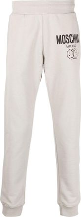 Moschino logo print tapered sweatpants - men - Cotton - 46 - Grey