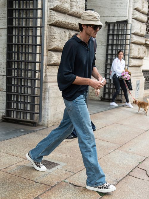 Jacob Elordi trägt einen schwarzen Hoodie, Bucket Hat, Jeans und Converse in Milan.