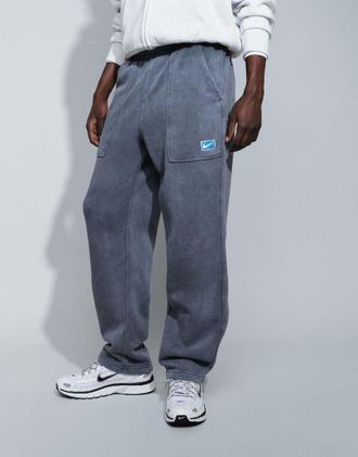 Nike joggers con grafica spray e fondo aperto in nero slavato