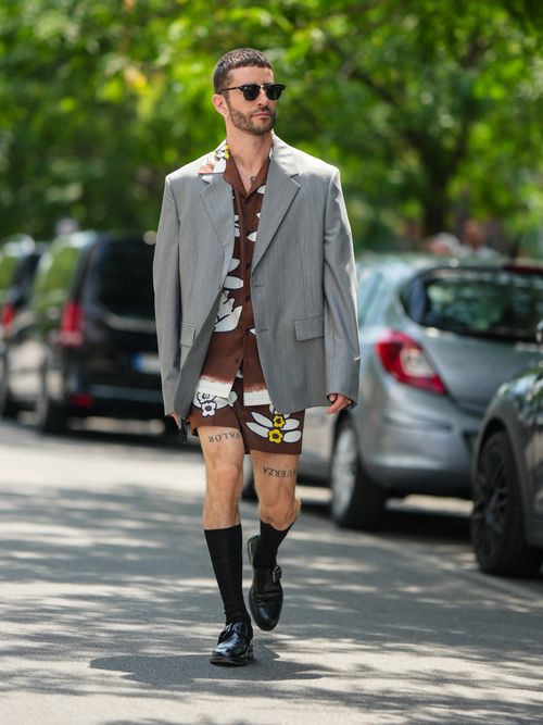 Pelayo Diaz trägt einen grauen Oversize-Blazer über ein Co-ord Look mit schwarzen Socken und Lederschuhen auf der Milan Fashion Week.