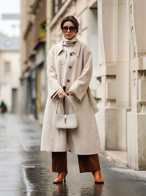 Streetstyle mit einer roten Hose zu einem beigen Pullover und Mantel.