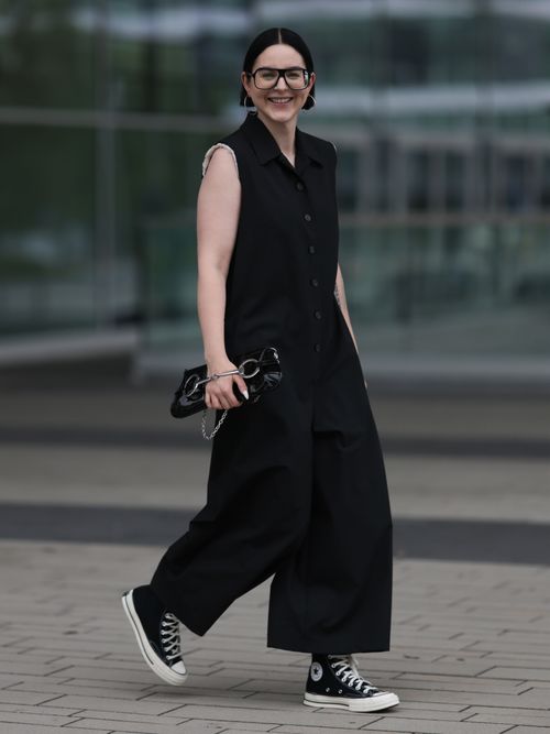 A guest wears an all black outfit with Converse Chuck Taylors