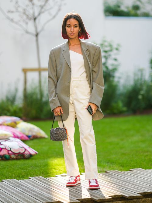 Streetstyle mit einer weißen Hose und Top zu einem oversized Blazer und Sneakers.
