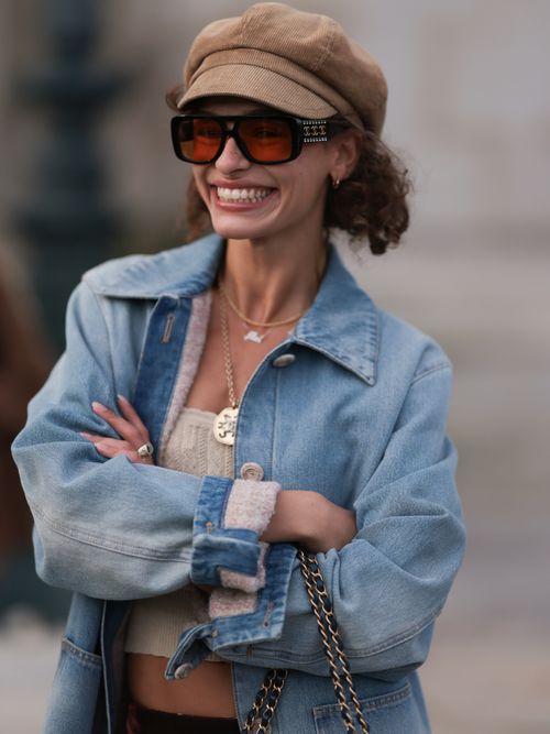 Melanie Kieback trägt eine Jeansjacke, Strick-Crop-Top, Sonnenbrille und Baker Boy Mütze auf der Paris Fashion Week.