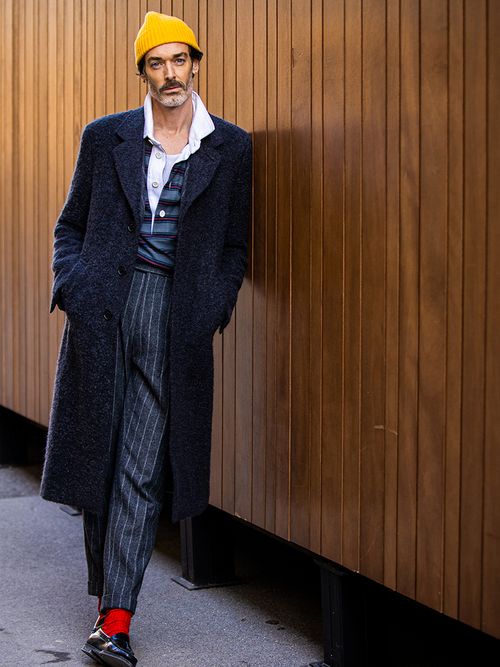 Streetstyle mit einem grauen Anzug zu einer gelben Wollmütze.