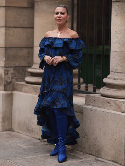Olga Ferrara trägt ein blaues Kleid mit Carmenausschnitt auf der Paris Fashion Week.