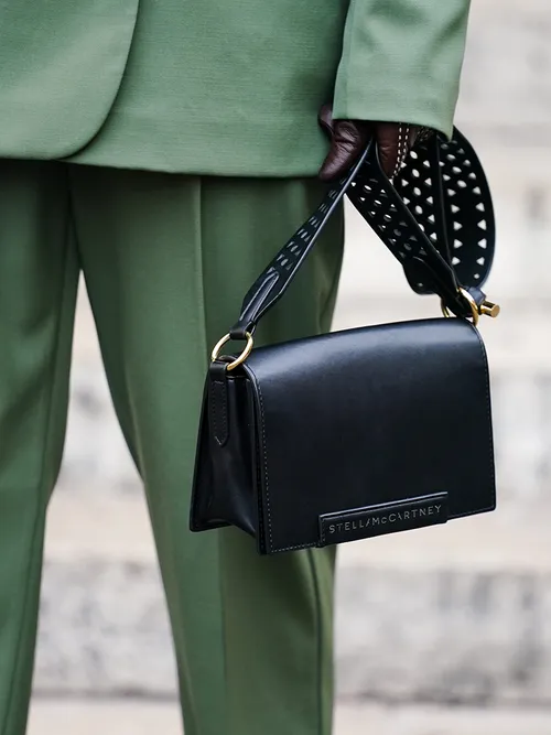 A guest wears an almond-green jacket, almond-green pants, a black Stella McCartney vegan leather bag, outside Stella McCartney , during Paris Fashion Week - Womenswear Spring Summer 2020, on September 30, 2019 in Paris, France.