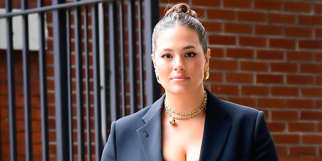 Ashley Graham in einem schwarzen Hosenanzug und goldenen Schmuck.