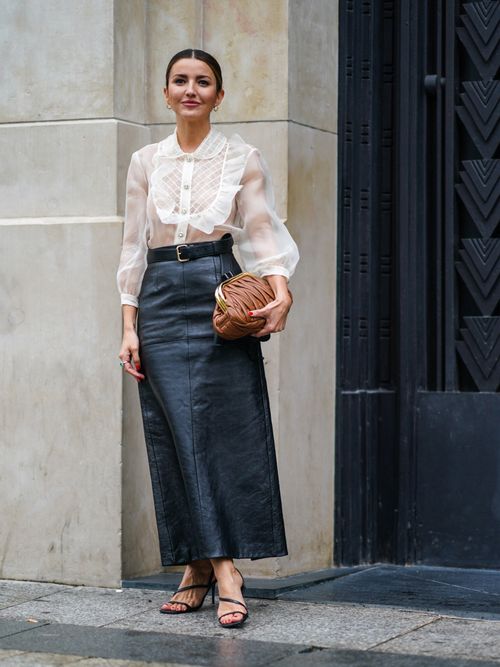 woman wearing black midi skirt in leather and white blouse
