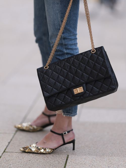 Close-up von Kitten Heels mit einer Skinny Jeans und gesteppter Handtasche