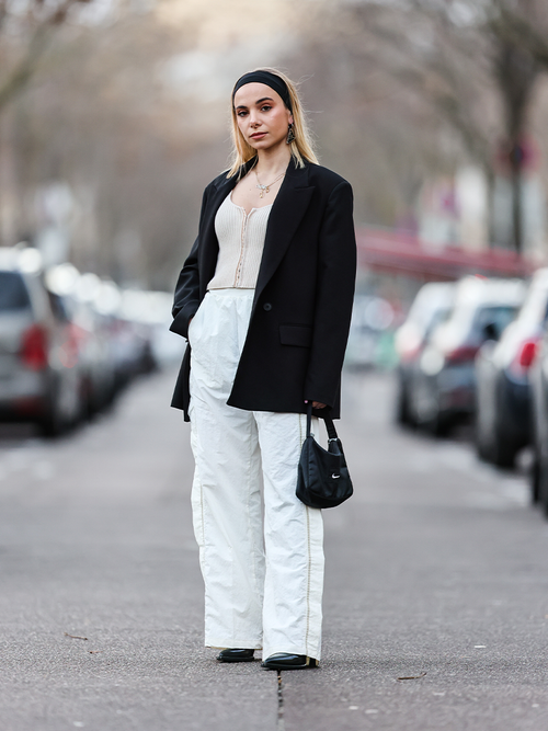 Streetstyle mit weißer Trainingshose, Top und einem schwarzen Blazer.
