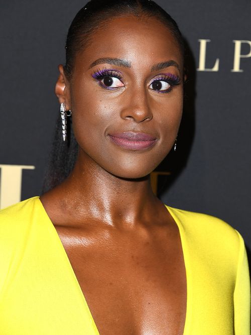 Issa Rae in einem gelben Oberteil und einem Lila Augen-Make-up