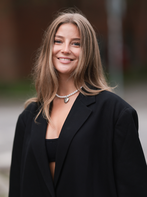 Rubi Stegle trägt einen schwarzen Blazer mit Perlenkette in Berlin.