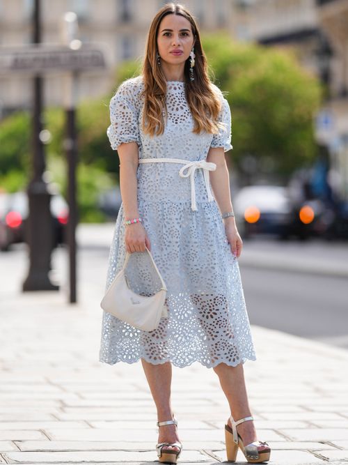 Maria Rosaria Rizzo trägt ein hellblaues Kleid aus Spitze mit weißem Gürtel und weißer Tasche in Paris.