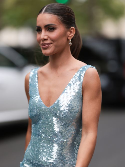Camila Coelho trägt ein türkises Pailettenkleid mit auffälligem Silberschmuck.