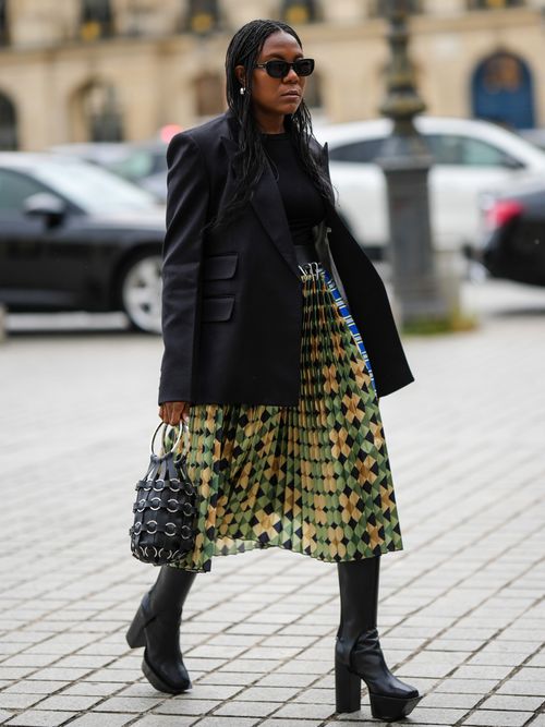 Street Style Look von einer Frau mit Midirock und Plateau Stiefel in Paris