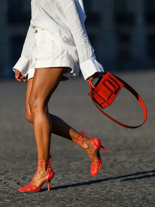 Orange Bottega Veneta sandals worn with a white shirt dress and orange bag