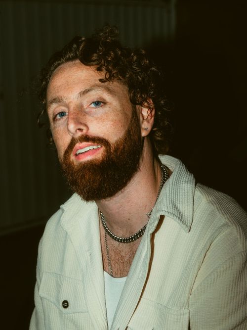 Mann mit Vollbart trägt ein pastellgrünes Hemd.