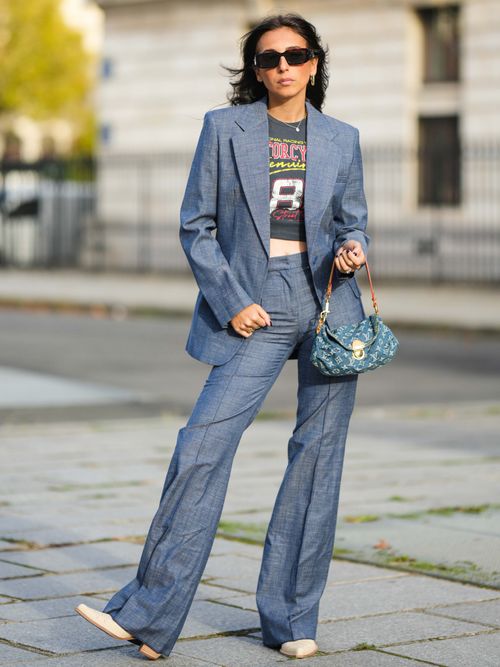 Gabriella Berdugo trägt einen blauen Leinen Anzug mit Band-T-Shirt darunter und Sonnenbrille in Paris.