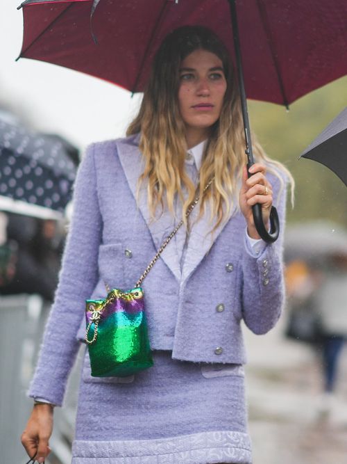 Veronika Heilbrunner in einem Lila-Tweet-Kostüm zu einer grünen Tasche.