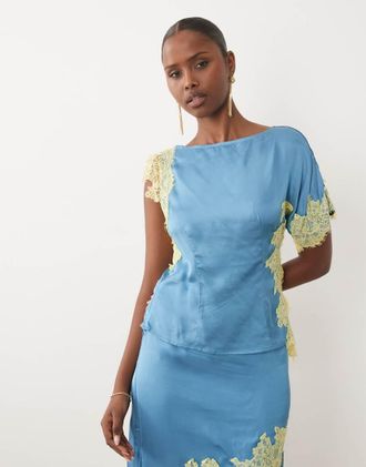 Never Fully Dressed Kira top coordinato in satin con scollo a barchetta asimmetrico, maniche corte e dettagli in pizzo, blu
