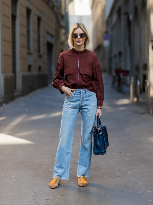 Lisa Hahnbueck trägt eine rote Bomberjacke mit Denim und Handtasche auf der Milan Fashion Week.