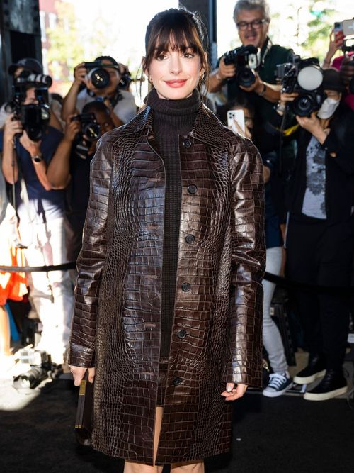 Anne Hathaway wears a brown croco leather coat with black turtle neck