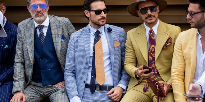 Eine Gruppe an Männern in maßgeschneiderten bunten Anzügen in Florenz.