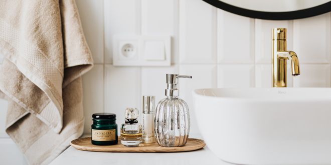 Weißes Waschbecken und ein Tablett mit Badezimmer Essentials.