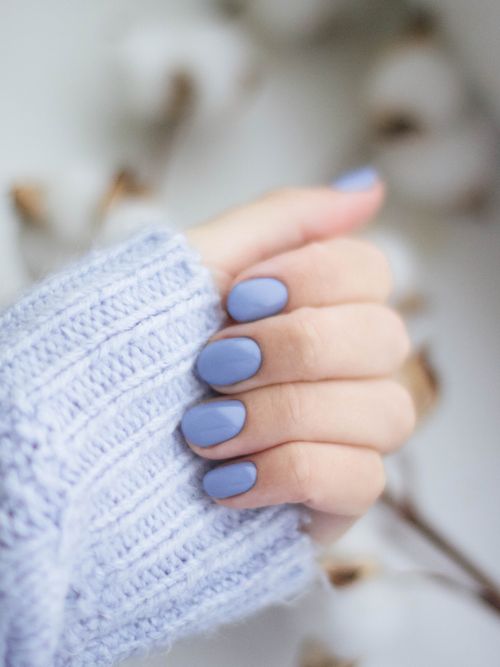 Detailfoto von fliederfarbenen Nägeln mit einem fliederfarbenen Strickpulli.