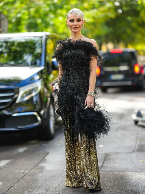 Ein Paris Fashion Week Gast trägt einen Pailletten Look mit Federn