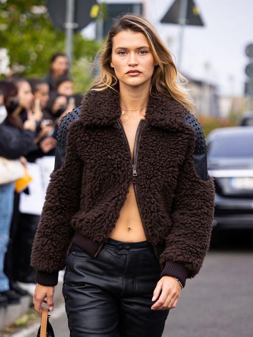 Chloe Lecareux is seen wearing a brown fur jacket with gommini details and black leather pants outside the Tod's show during the Milan Fashion Week - Womenswear Spring/Summer 2023 on September 23, 2022 in Milan, Italy.