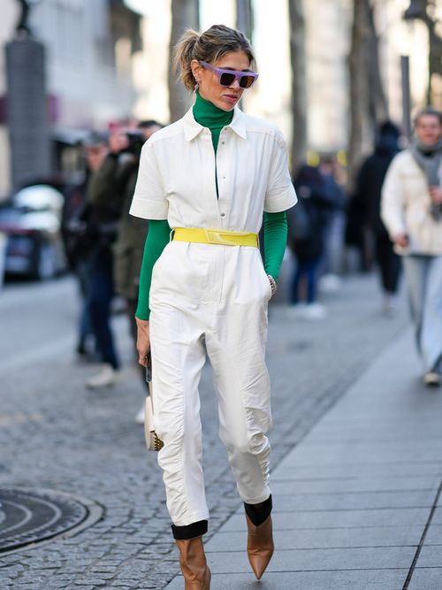 Streetstyle mit einem weißen Overall und einem grünen Rollkragenpullover.