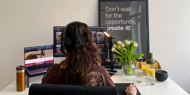Office space with monitor, lamp, water bottle, thermos, and flowers