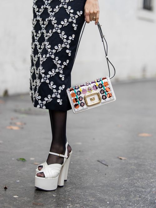 Fer Millan Delaroiere wears skirt, white bag Roger Vivier, tights, platform sandals outside of 