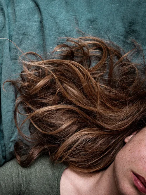 Close-up von rot-braunem, welligem Haar.