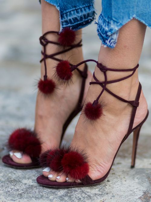 Close-up von einem Street Style Look in Berlin. Ein Gast trägt Aquazzura Sandaletten mit einer Jeans und weißem Nagellack an den Füßen.
