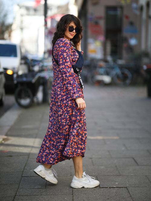 Streetstyle mit einem langärmligen Blumenkleid, weißen Sneakers und Gürteltasche.