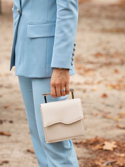 Influencerin Victoria Magrath trägt eine hellblauen Balmain Hosenanzug und eine Handtasche von Mashu.