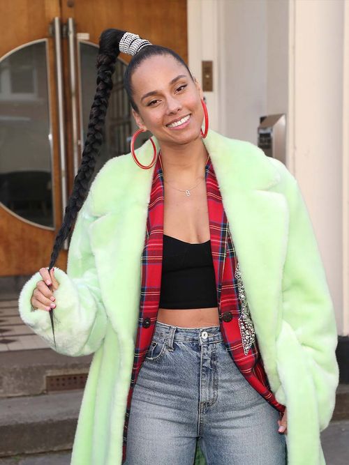 Alicia Keys in einer Jeans, einem Karohemd und einer grünen Felljacke.